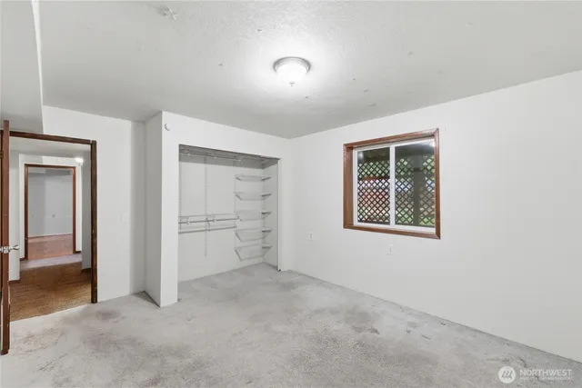 an empty room with closet and windows