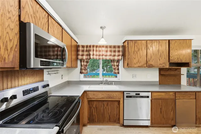 a kitchen with granite countertop a stove a sink and a microwave