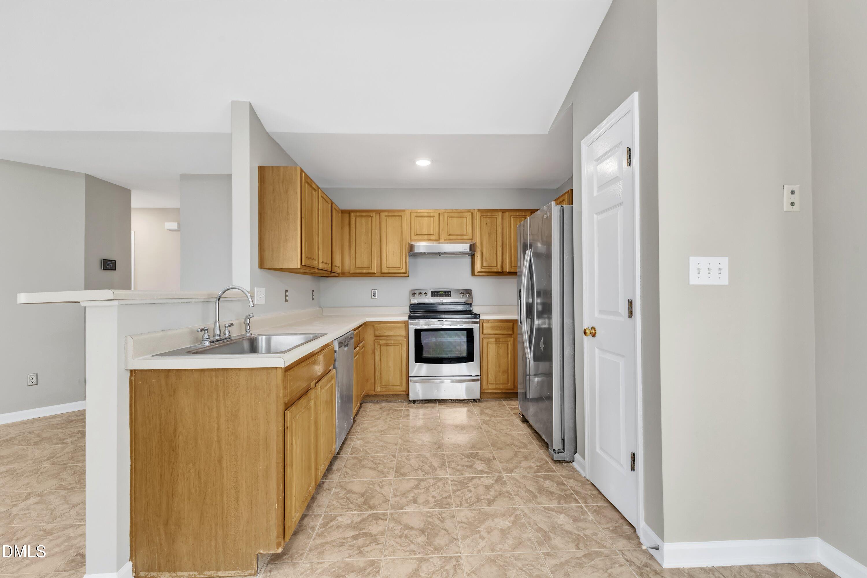 4917 Silverdene Street Raleigh, NC 27616 - Photo 15 of 35 a large kitchen with a stove top oven sink and cabinets