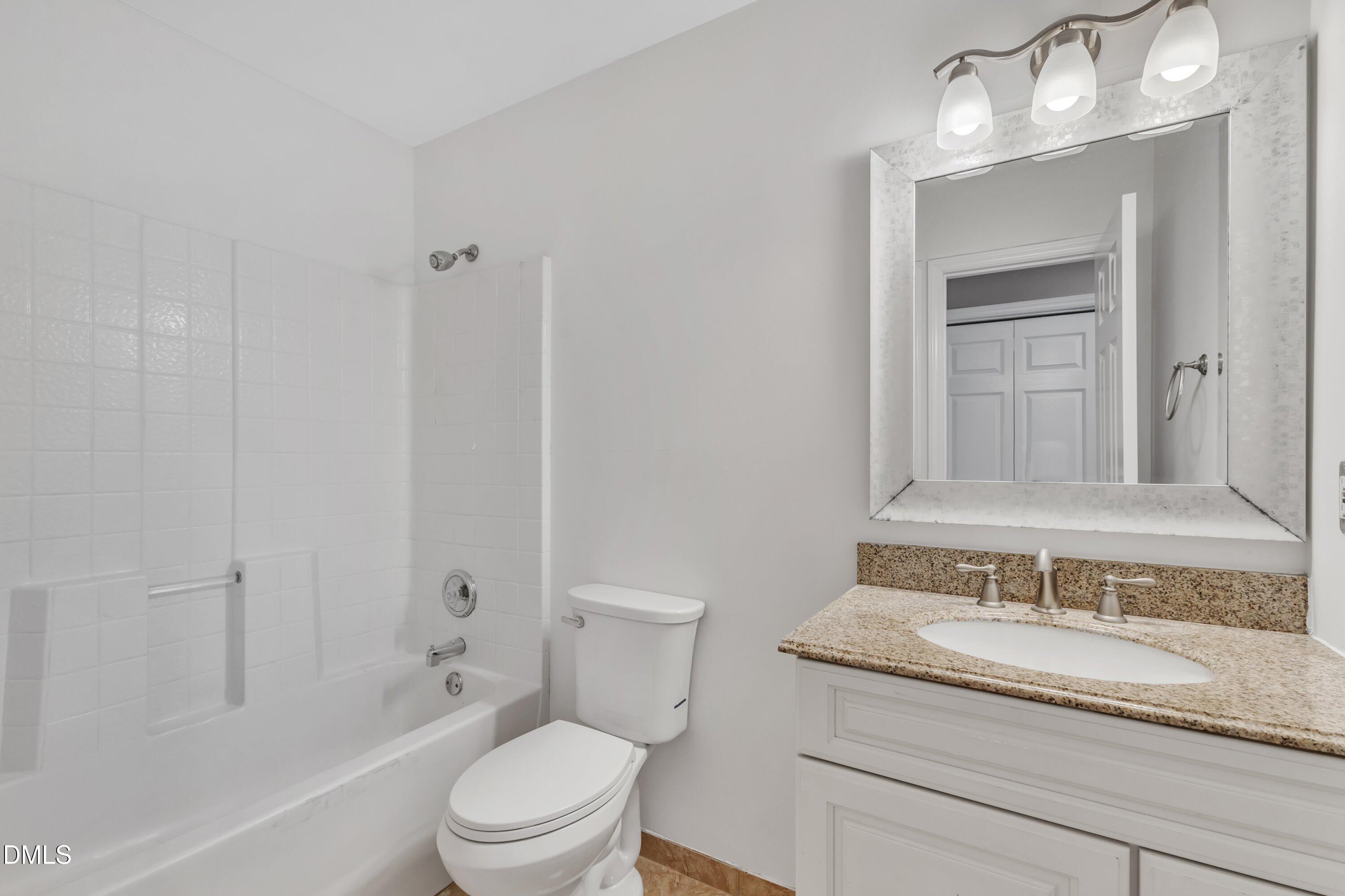 4917 Silverdene Street Raleigh, NC 27616 - Photo 25 of 35 a bathroom with a granite countertop sink a toilet and shower