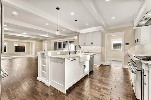a kitchen with stove and wooden floor
