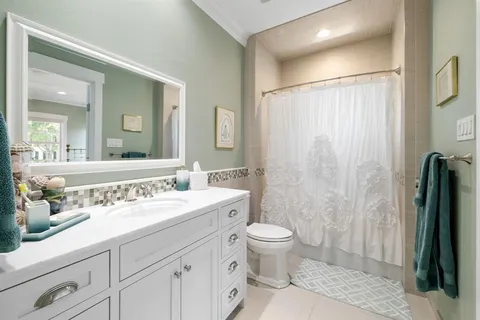 a spacious bathroom with a sink a toilet and a mirror