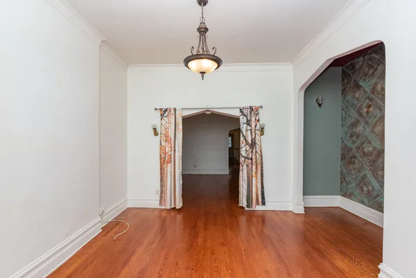 a view of a room with wooden floor and ceiling fan
