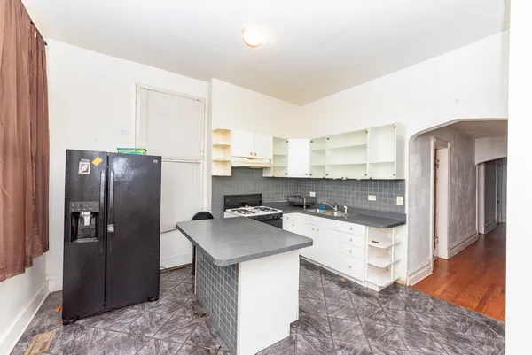 a kitchen with stainless steel appliances a refrigerator a stove a sink and white cabinets