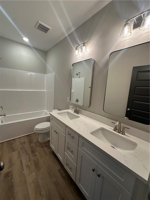 5207 Lee Road Salem, AL 36874 - Photo 16 of 23 Full bath with dark wood-style floors, double vanity, and bathtub / shower combination