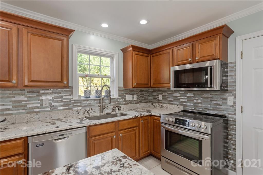 312 Black River Road Fletcher, NC 28732 - Photo 14 of 29 a kitchen with granite countertop a sink stove and microwave