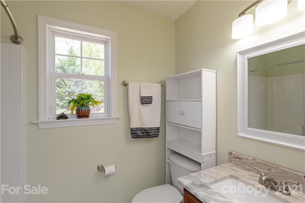 312 Black River Road Fletcher, NC 28732 - Photo 22 of 29 a bathroom with a granite countertop sink toilet and a window