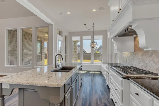 a kitchen with granite countertop a stove and a sink