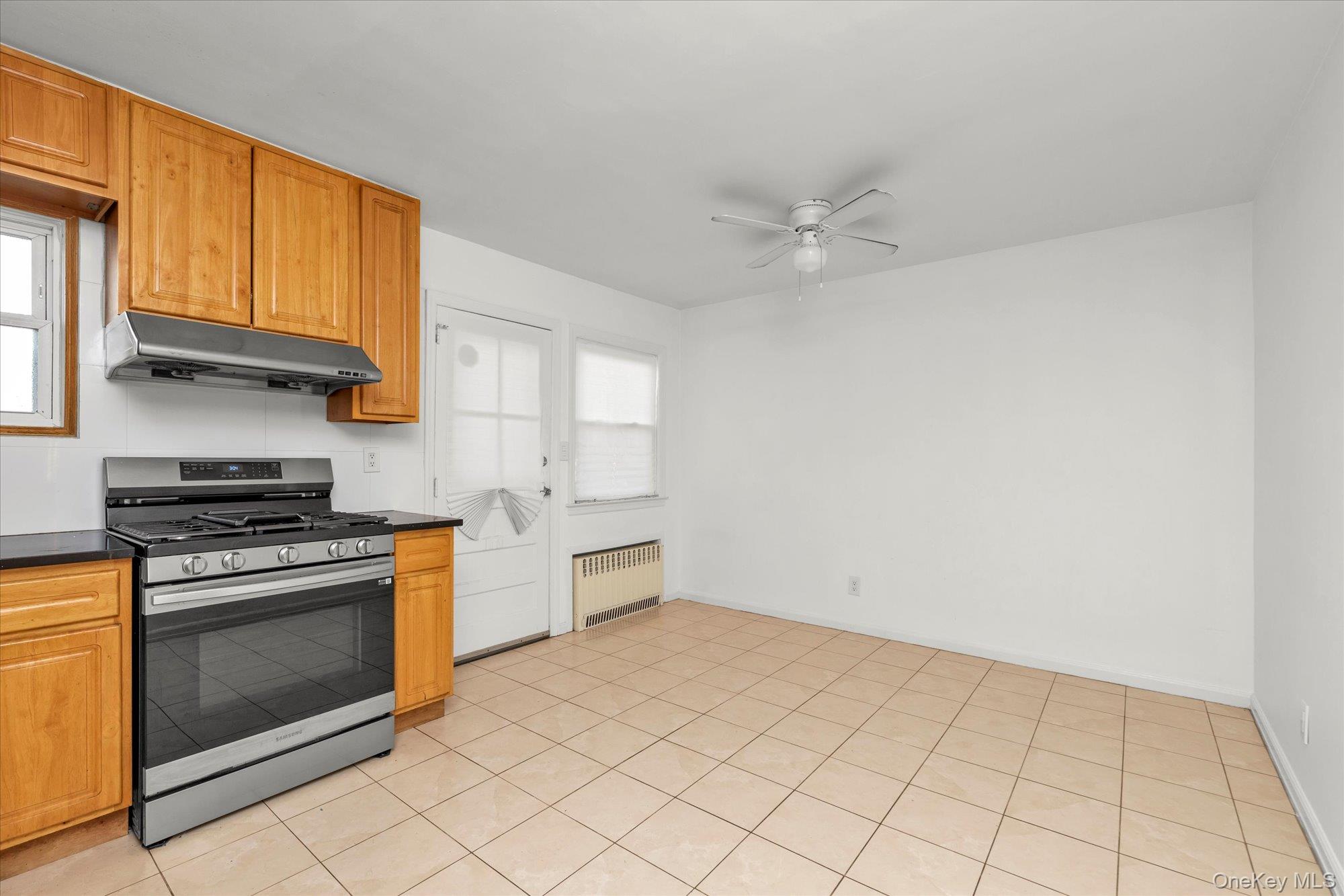 5 White Street Valley Stream, NY 11580 - Photo 7 of 23 a kitchen with granite countertop a stove top oven a sink and dishwasher