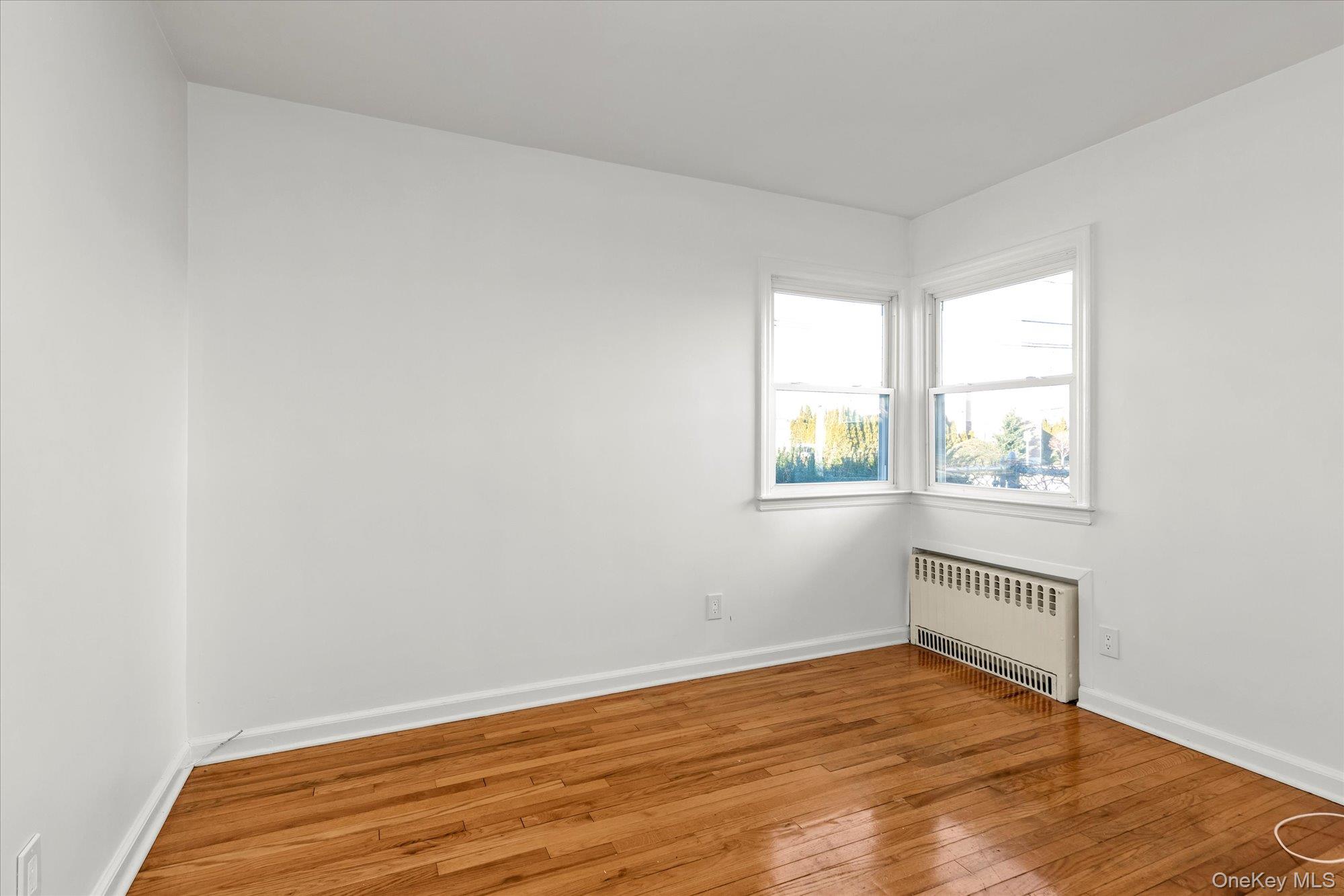 5 White Street Valley Stream, NY 11580 - Photo 9 of 23 an empty room with wooden floor and windows