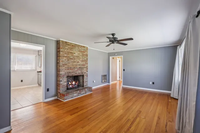 a view of an empty room with a fireplace and a window
