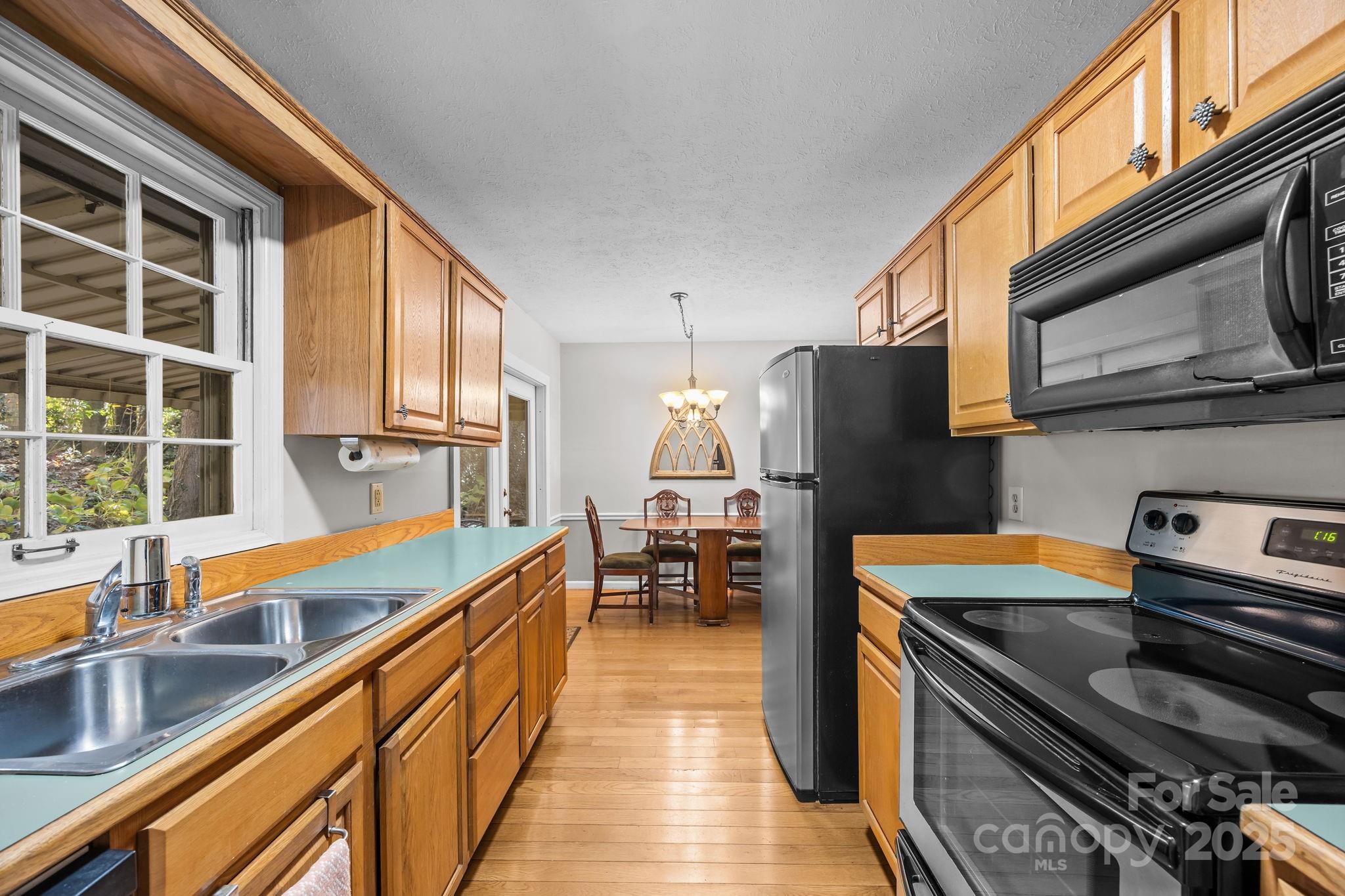 3228 Sweeten Creek Road Asheville, NC 28803 - Photo 34 of 48 a kitchen with stainless steel appliances sink stove microwave and cabinets