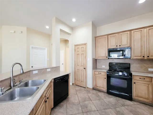 an empty room with a chandelier fan and windows