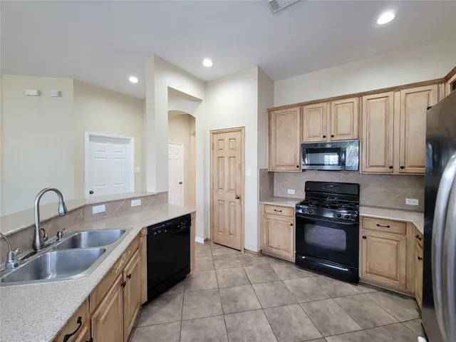 a view of a backyard with table and chairs and a large tree