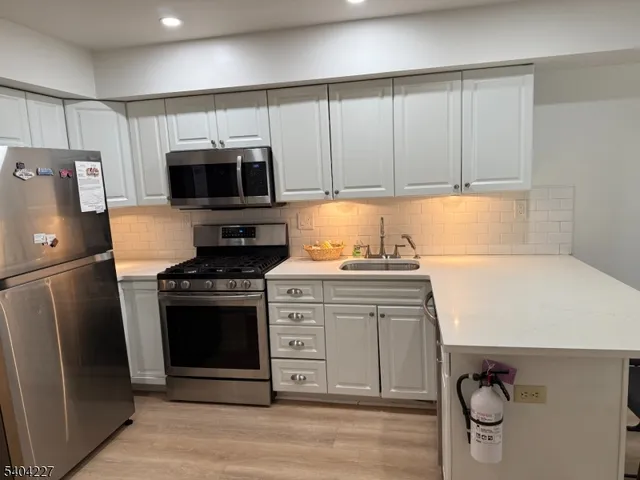 a kitchen with granite countertop a stove and a refrigerator