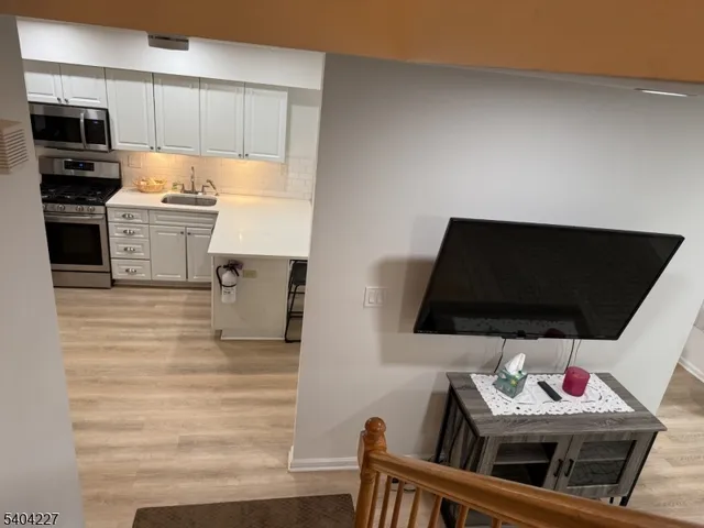 a kitchen with stainless steel appliances kitchen island granite countertop a stove and a microwave