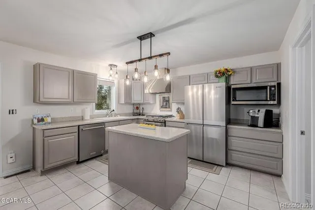 a kitchen with stainless steel appliances granite countertop a refrigerator and a sink
