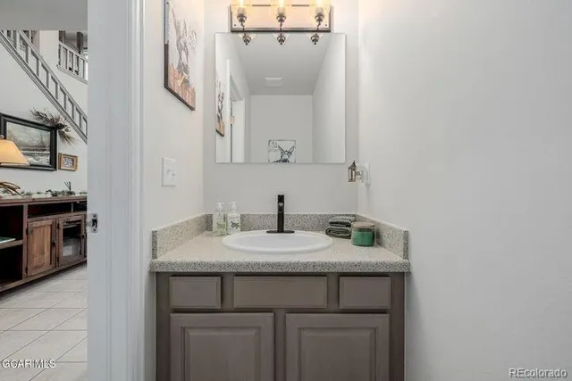 a bathroom with a granite countertop sink and a mirror