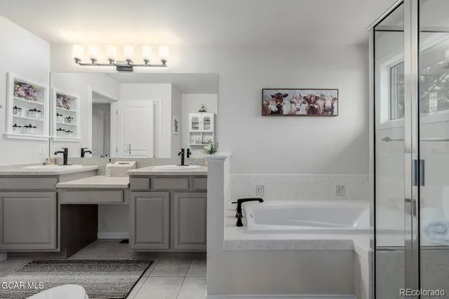 a bathroom with a tub a sink and mirror