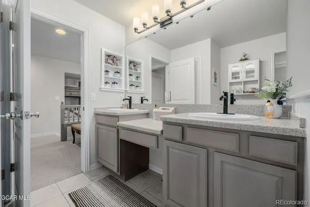 a bathroom with double vanity and a mirror