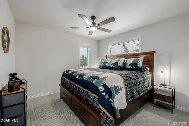 a bedroom with a bed and a ceiling fan