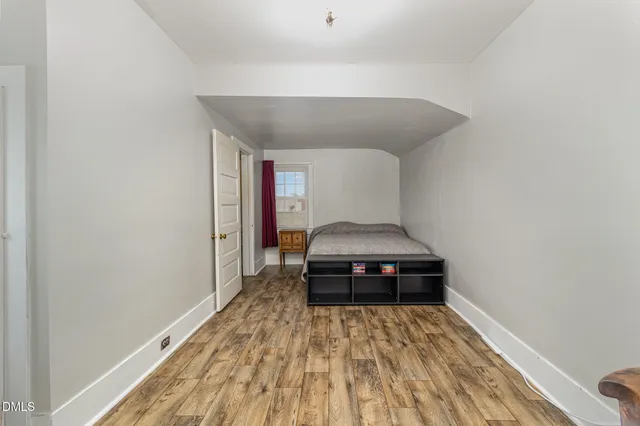 a bedroom with a bed and a wooden floor