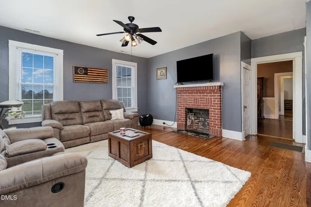 a living room with furniture a flat screen tv and a fireplace