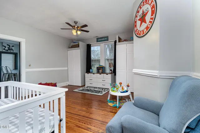 a living room with furniture and a dining table with wooden floor