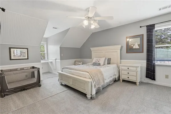 a bedroom with a large bed and a chandelier