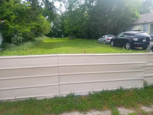 a view of backyard with table and chairs and plants