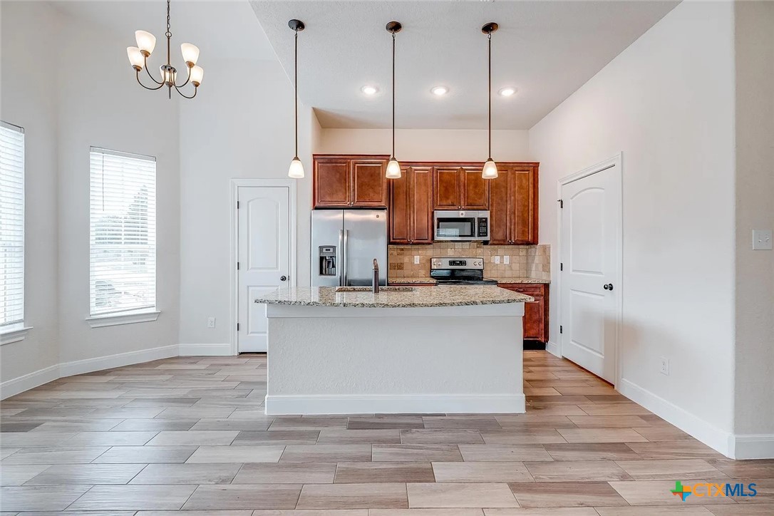 3133 Puter Creek Road, Unit B Spring Branch, TX 78070 - Photo 8 of 19 a view of kitchen with granite countertop cabinets a stove a sink and a potted plant