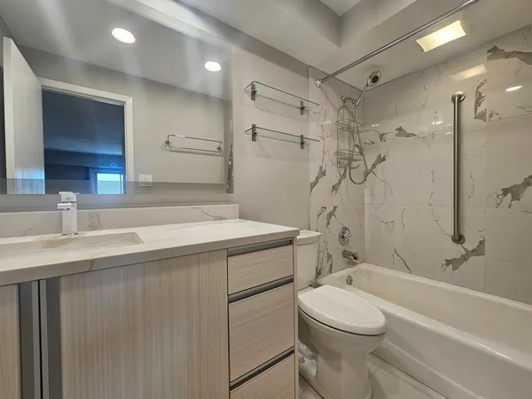 a bathroom with a sink a toilet and shower