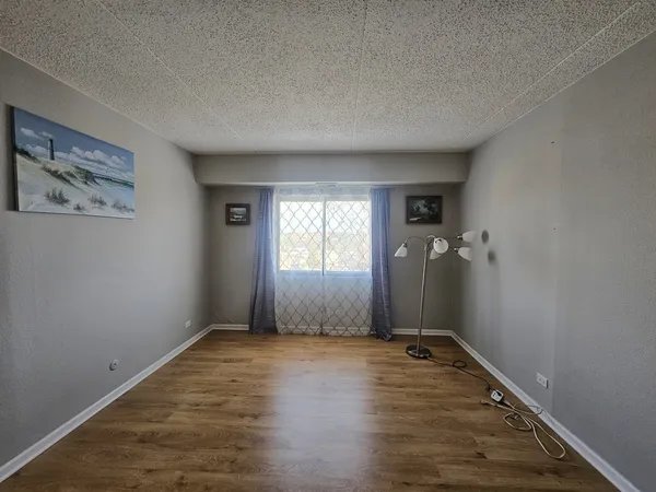 an empty room with wooden floor and a window