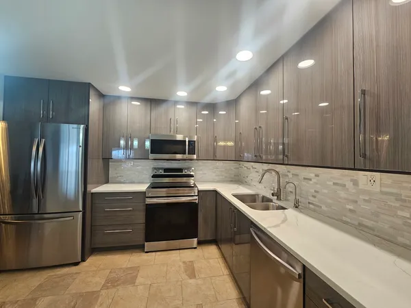 a kitchen with stainless steel appliances granite countertop a sink stove and refrigerator