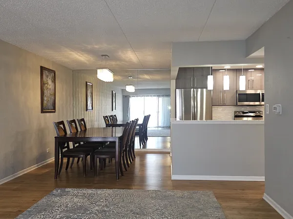 a view of a a dining room with furniture window and wooden floor