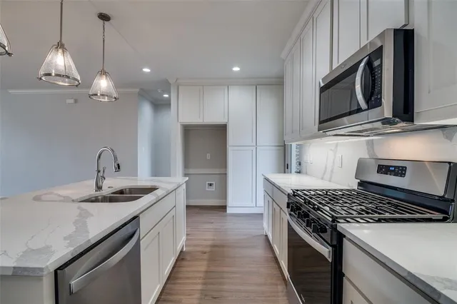 a kitchen with stainless steel appliances granite countertop a sink a stove and a microwave