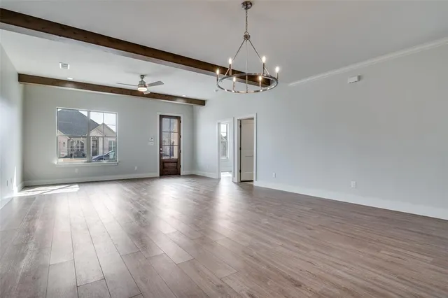 a view of a room with wooden floors and ceiling fan
