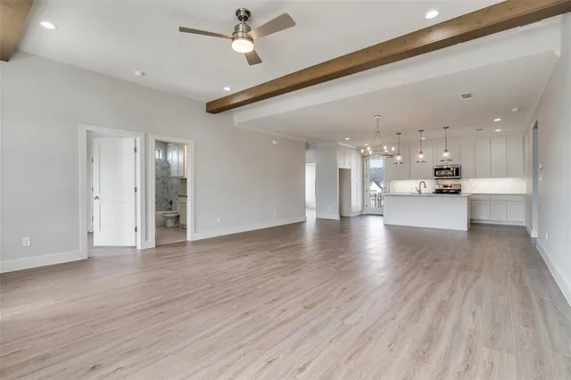 a view of a big room with wooden floor kitchen view and a window