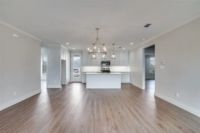 a large kitchen with granite countertop a large counter top stainless steel appliances and cabinets