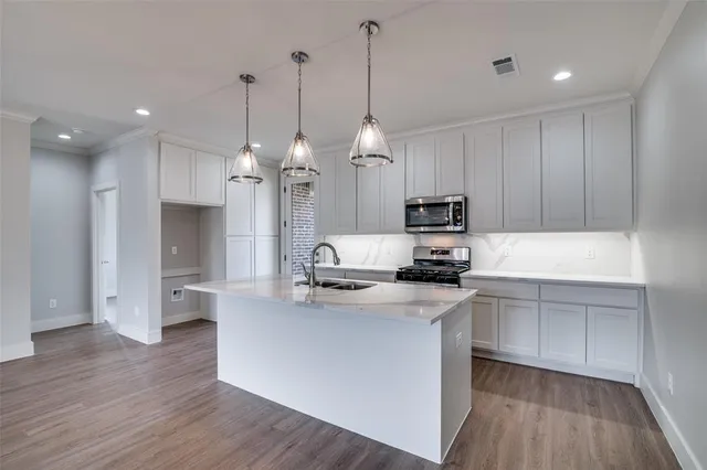 a kitchen with kitchen island a sink stainless steel appliances and cabinets