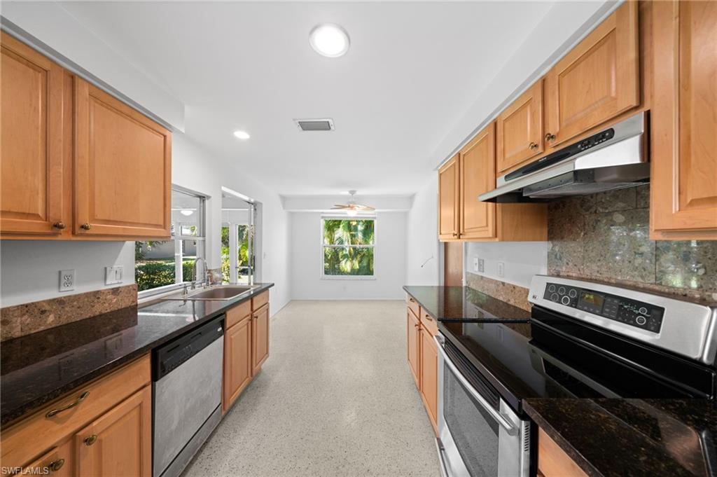 6 Maui Circle Naples, FL 34112 - Photo 8 of 22 a kitchen with a sink stove and cabinets