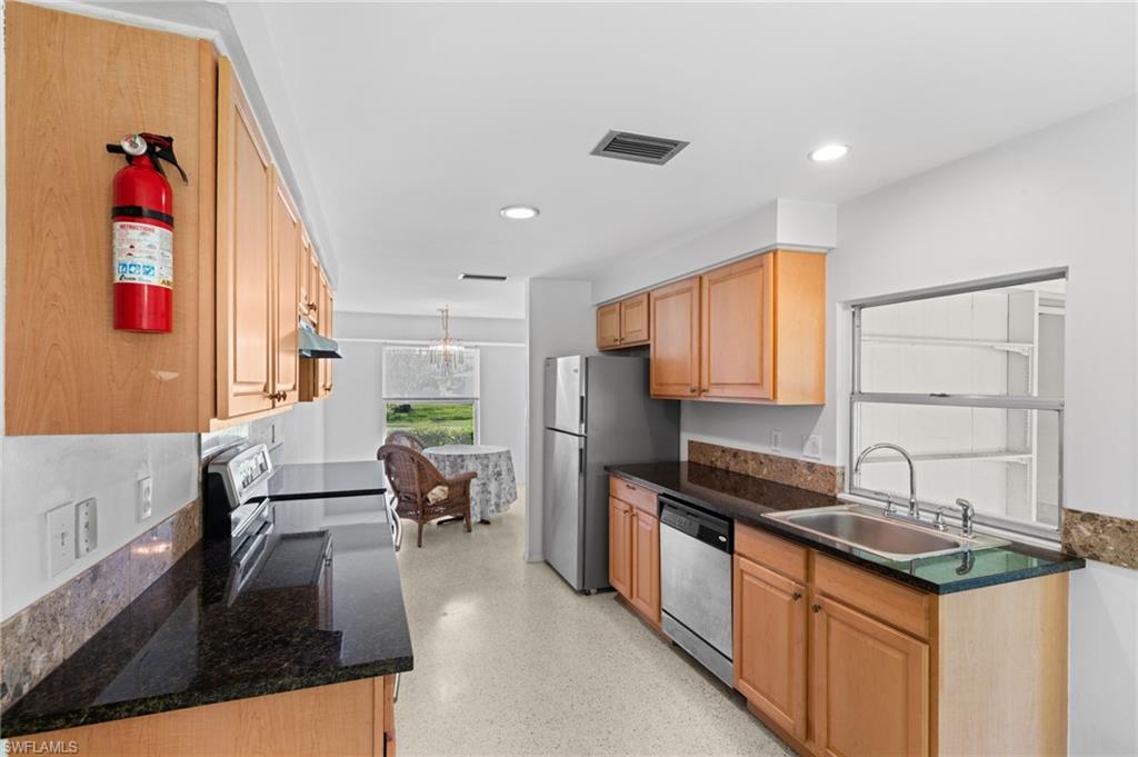 6 Maui Circle Naples, FL 34112 - Photo 9 of 22 a kitchen with a sink stove and cabinets