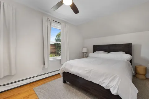 a large bed sitting in a bedroom next to a window