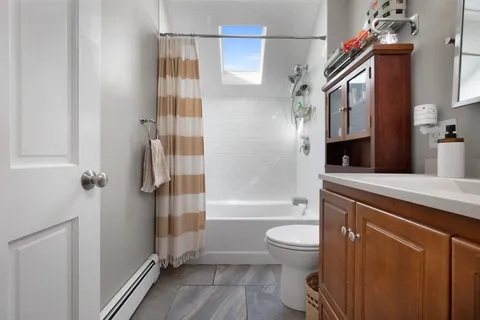 a bathroom with a bathtub shower sink mirror and toilet