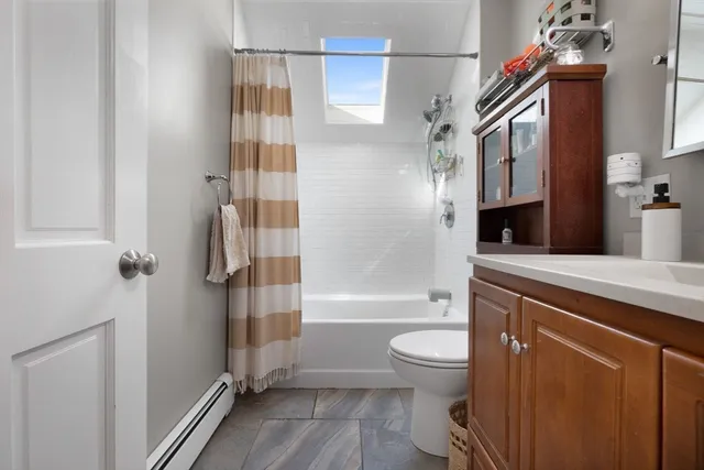 a bathroom with a bathtub shower sink mirror and toilet