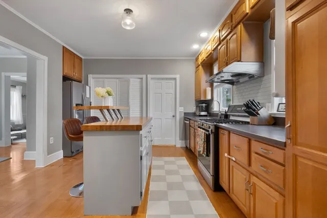 a kitchen with kitchen island granite countertop lots of counter top space and stainless steel appliances