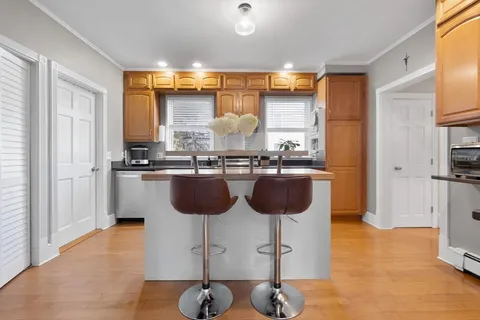 a kitchen with a sink and chairs