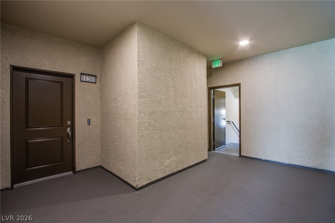 An inviting private entrance vestibule features durable concrete flooring under recessed illumination.