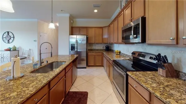 a kitchen with kitchen island a dining table chairs and a refrigerator