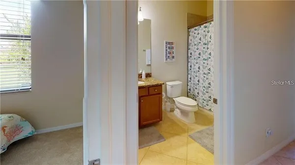 a bathroom with a granite countertop toilet and a sink
